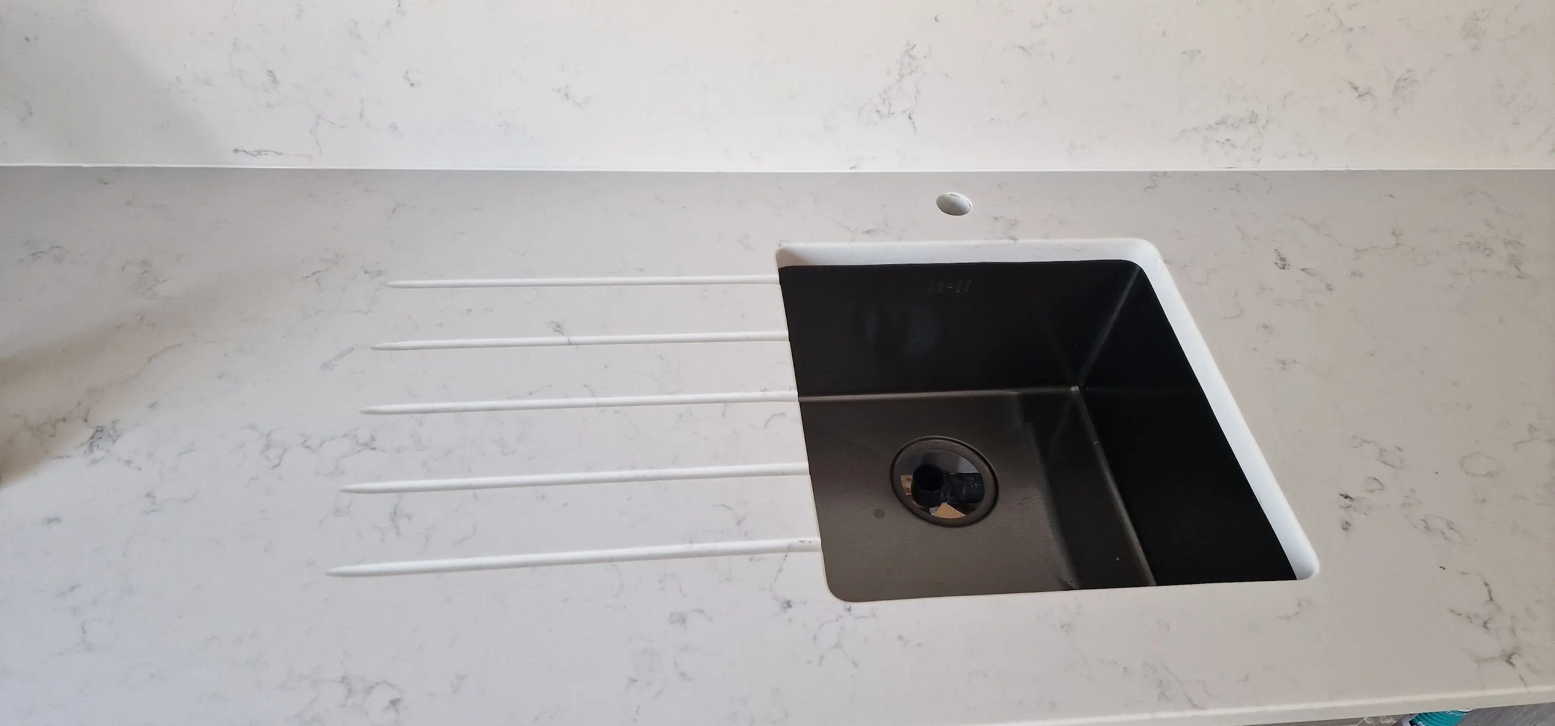 Quartz worktop with undermount sink cut-out and drainer grooves in Northolt